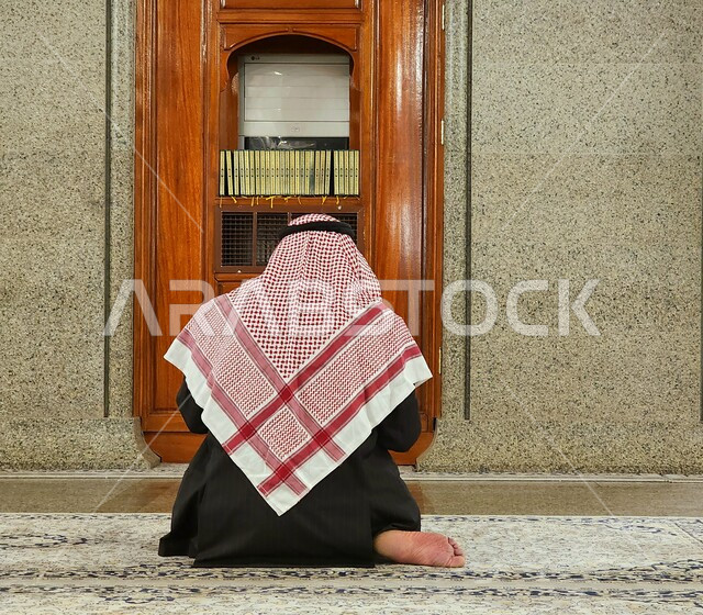 مساجد تاريخية واثرية في المدينة المنورة، صورة مقربة من الخلف لرجل عربي خليجي سعودي يرتدي الشماغ والثوب التقليدي يجلس في مسجد قباء مقابل المكتبة، العبادة والتقرب إلى الله، أماكن ومعالم دينية مقدسة في المملكة العربية السعودية