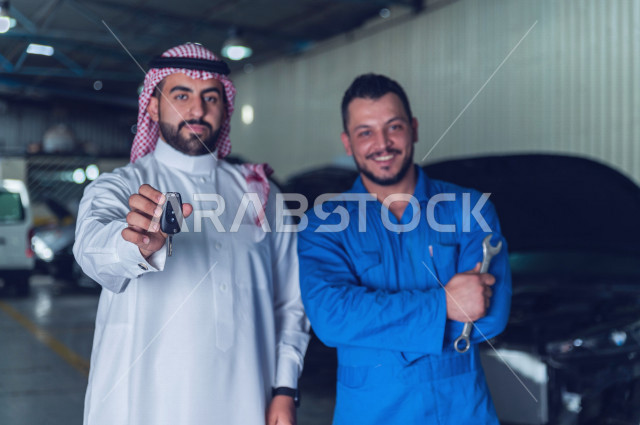 A Saudi Arab man stands with the mechanical engineer inside the auto workshop, handing over the car keys to the worker, car repair and maintenance services, a mechanical engineer, a maintenance workshop