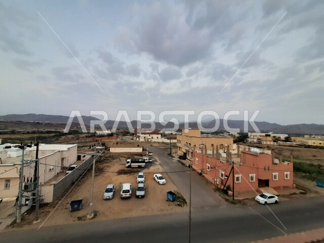 السماء الزرقاء المليئة بالغيوم البيضاء في فصل الشتاء، صورة من الأعلى لشوارع مدينه الحجرة بمنطقه الباحه جنوب المملكة العربية السعوديه في الصباح، الفن الهندسي المعماري للأبنية والمنشآت السكنية