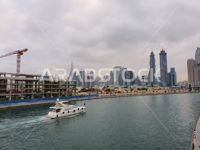 الواجهة البحرية على ساحل الخليج العربي، حركة اليخوت والسفن في بحر مارينا دبي في النهار, الفن الهندسي المعماري للمباني والمنشآت المطلة على المرفأ، النمو والتطور العمراني للأبراج وناطحات السحاب في دولة الإمارات العربية المتحدة، معالم إمارة دبي السياحية المشهورة
