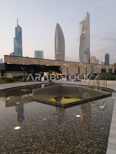 المسطحات المائية والبحيرات في المنتزهات والحدائق العامة في دولة الكويت، الفن الهندسي المعماري للأبراج المطلة على حديقة الشهيد في منطقة الكويت الثقافية الوطنية الجديدة، المناطق والأماكن العائلية للتنزه والمتعة، المروج الخضراء والأشجار والبيئة الطبيعية وقت الغروب