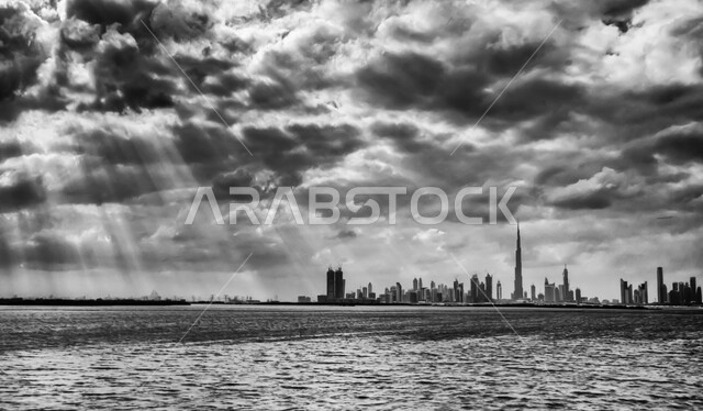 صورة بالأسود والأبيض لأفق دبي، التطور العمراني الهندسي الفني للأبراج وناطحات السحاب في دولة الإمارات العربية المتحدة, الفن المعماري على الطراز الحديث والمتطور للمباني على الواجهة البحرية, معالم وأماكن السياحة المشهورة, الأجواء الغائمة ومنظر السماء المليئة بالسحب 