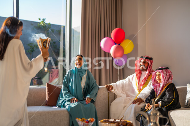 ارتداء الملابس التقليدية احتفالا بالعيد، فتاة عربية خليجية سعودية ترتدي العباءة تمسك بيدها حامل البخور، تبخير وتعطير وتطييب الأسرة بالمسك والعود، ايماءات البهجة والسرور
