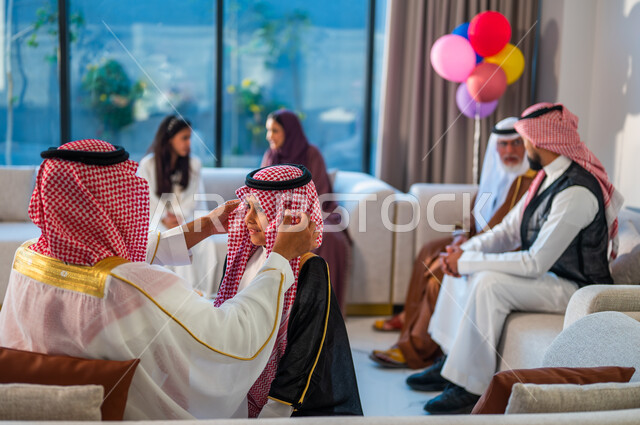 بهجة العيد في المنازل العربية السعودية، صورة مقربة من الخلف لرجل يرتدي الزي التقليدي،  قضاء اوقات ممتعة مع الأبناء، أعياد ومناسبات دينية، استخدام البوالين في الزينة