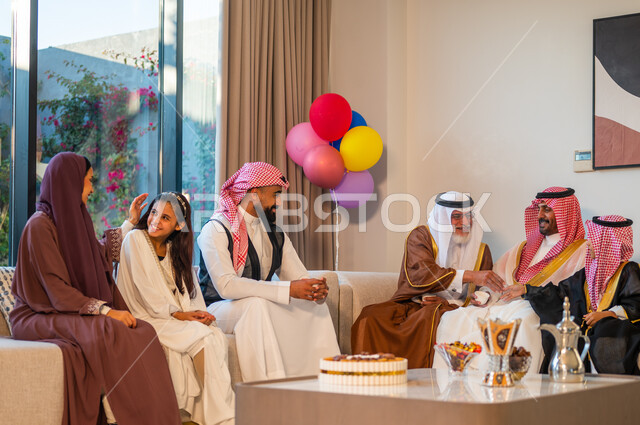 ايماءات البهجة والسرور، ارتداء الملابس التقليدية في الأعياد و المناسبات الدينية، عائلة عربية خليجية سعودية تحتفل بقدوم العيد، قضاء اوقات ممتعة مع الأبناء، استخدام البوالين في الزينة