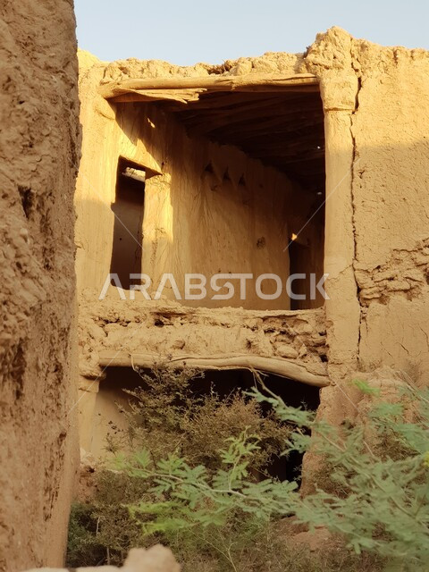 Archaeological historical areas and landmarks in the city of Riyadh, the growth of natural trees and green plants in tourist cities in the Kingdom of Saudi Arabia, demolished heritage mud houses and buildings in the old city during the day, ancient architecture in the village of Jalajel in Al Majmaah Governorate.