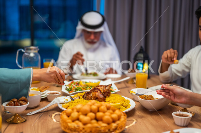 أطعمة و حلويات شرقية لذيذة، أجواء دينية رمضانية، صورة مقربة لسفرة مليئة باصناف من المأكولات الشهية، اجتماع الأسرة حول مائدة الطعام، أداء فريضة الصيام، عائلة عربية خليجية سعودية