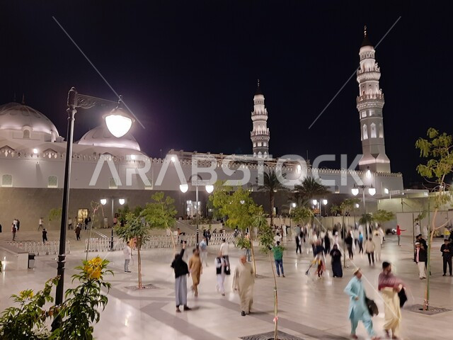 تجمع المصلين والزائرين في الفناء الخارجي للجامع، الفن الهندسي المعماري المتميز والديكورات الاسلامية على الطراز الحديث، العبادة والتقرب إلى الله، مآذن و قبب مسجد قباء المضيئة في المدينة المنورة ليلا، معالم و أماكن دينية مقدسة في المملكة العربية السعودية