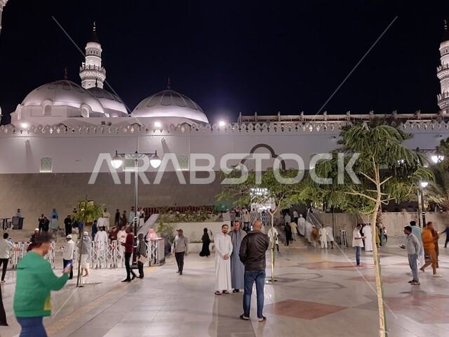 تجمع المصلين والزائرين في الفناء الخارجي للجامع، الفن الهندسي المعماري المتميز والديكورات الاسلامية على الطراز الحديث، العبادة والتقرب إلى الله، مآذن و قبب مسجد قباء المضيئة في المدينة المنورة ليلا، معالم و أماكن دينية مقدسة في المملكة العربية السعودية