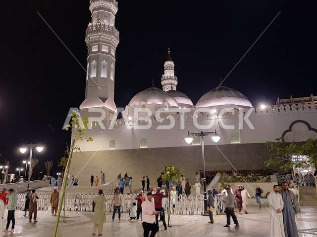 تجمع المصلين والزائرين في الفناء الخارجي للجامع، الفن الهندسي المعماري المتميز والديكورات الاسلامية على الطراز الحديث، العبادة والتقرب إلى الله، مآذن و قبب مسجد قباء المضيئة في المدينة المنورة ليلا، معالم و أماكن دينية مقدسة في المملكة العربية السعودية