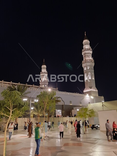 تجمع المصلين والزائرين في الفناء الخارجي للجامع، الفن الهندسي المعماري المتميز والديكورات الاسلامية على الطراز الحديث، العبادة والتقرب إلى الله، مآذن و قبب مسجد قباء المضيئة في المدينة المنورة ليلا، معالم و أماكن دينية مقدسة في المملكة العربية السعودية