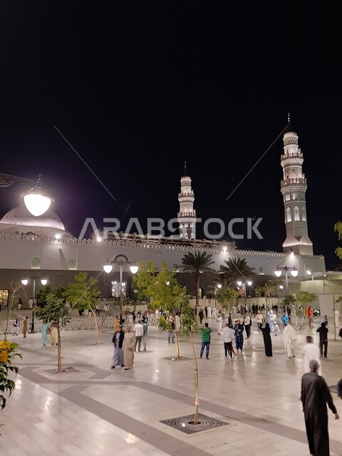 العبادة والتقرب إلى الله، الفن الهندسي المعماري المتميز والديكورات الاسلامية على الطراز الحديث، مآذن و قبب مسجد قباء المضيئة في المدينة المنورة ليلا، تجمع المصلين والزائرين في الفناء الخارجي للجامع، معالم و أماكن دينية مقدسة في المملكة العربية السعودية