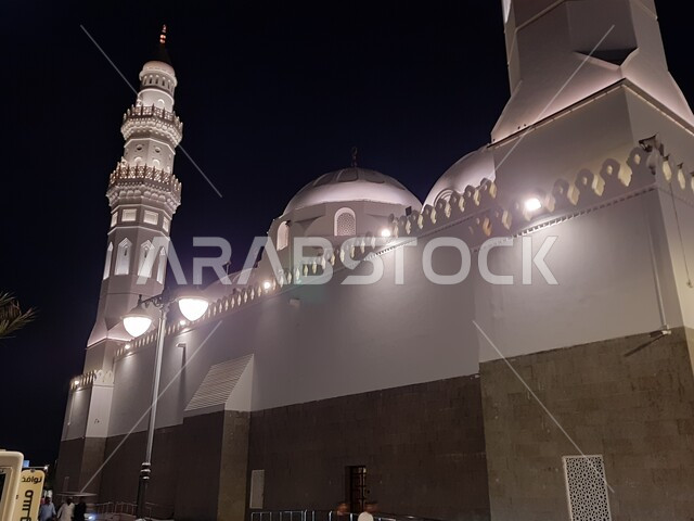 مآذن و قبب مسجد قباء المضيئة في المدينة المنورة ليلا، الفن الهندسي المعماري المتميز والديكورات الاسلامية على الطراز الحديث، العبادة والتقرب إلى الله، المصلين والزائرين في الفناء الخارجي للجامع، معالم و أماكن دينية مقدسة في المملكة العربية السعودية