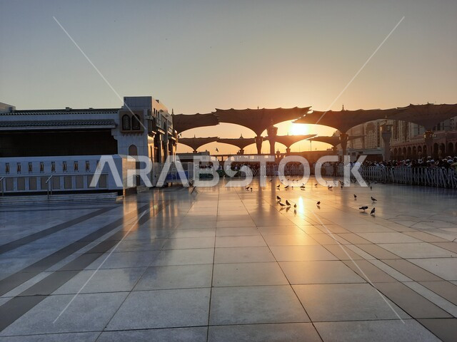 View of the sky at sunset over the Prophet’s Mosque in Medina, sacred religious places and landmarks in the Kingdom of Saudi Arabia, minarets and electronic canopies, architectural engineering art of mosques in the Islamic style