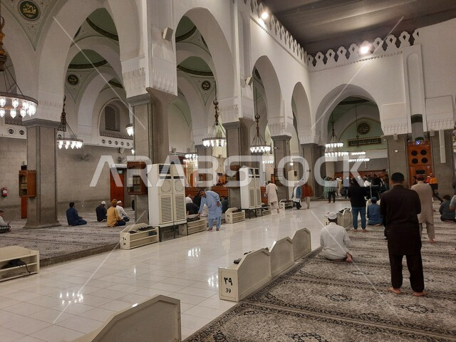 الديكورات والزخارف الإسلامية، أماكن دينية مقدسة، العبادة والتقرب الى الله، التصميم الداخلي على الطراز الإسلامي، مجموعة من المصليين داخل مسجد قباء في المدينة المنورة بالمملكة العربية السعودية