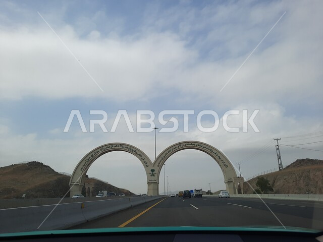Entry gate to Mecca, the borders of the Holy Mosque in Mecca, famous Islamic religious landmarks in the Kingdom of Saudi Arabia, paved roads and streets, means of transportation, car traffic