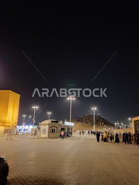 تجمع المسلمين من شتى أنحاء العالم أمام نصب شهداء أحد في المدينة المنورة ليلا، مزارات ومعالم دينية سياحية في المملكة العربية السعودية، أماكن اسلامية مقدسة مشهورة، الأجواء والمشاعر الروحانية، القمم والمرتفعات الجبلية