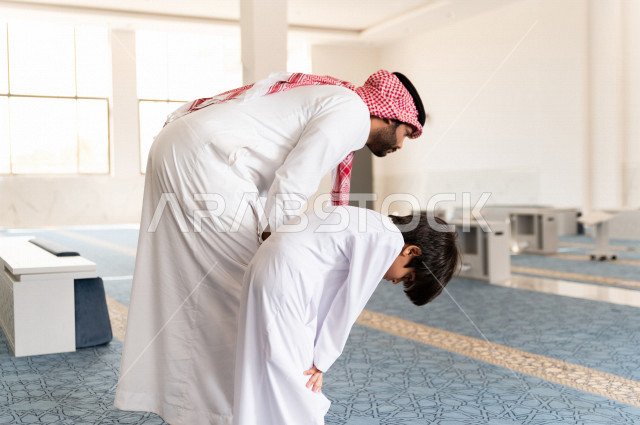 تعليم أداء فريضة الصلاه للطفل داخل المسجد، رجل سعودي يصلي في المصلى بجانب ابنه البالغ ،الخشوع في الصلاه ، أداء فريضة الصلاه في المسجد ، العبادة و التقرب الى الله ، تعليم الصلاة للأطفال