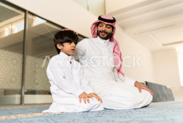 تعليم أداء فريضة الصلاه للطفل داخل المسجد، رجل سعودي يصلي في المصلى بجانب ابنه البالغ ،الخشوع في الصلاه ، أداء فريضة الصلاه في المسجد ، العبادة و التقرب الى الله ، تعليم الصلاة للأطفال