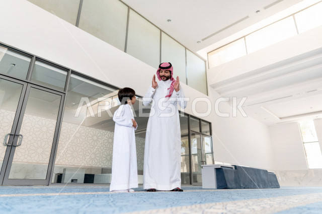 تعليم أداء فريضة الصلاه للطفل داخل المسجد، رجل سعودي يصلي في المصلى بجانب ابنه البالغ ،الخشوع في الصلاه ، أداء فريضة الصلاه في المسجد ، العبادة و التقرب الى الله ، تعليم الصلاة للأطفال