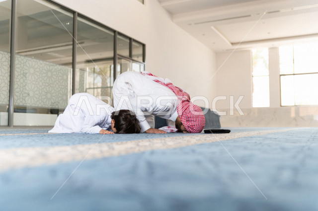 تعليم أداء فريضة الصلاه للطفل داخل المسجد، رجل سعودي يصلي في المصلى بجانب ابنه البالغ ،الخشوع في الصلاه ، أداء فريضة الصلاه في المسجد ، العبادة و التقرب الى الله ، تعليم الصلاة للأطفال