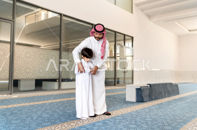 تعليم أداء فريضة الصلاه للطفل داخل المسجد، رجل سعودي يصلي في المصلى بجانب ابنه البالغ ،الخشوع في الصلاه ، أداء فريضة الصلاه في المسجد ، العبادة و التقرب الى الله ، تعليم الصلاة للأطفال