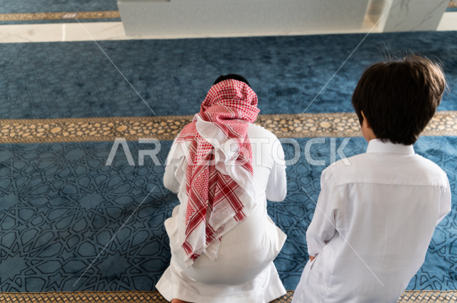 تعليم أداء فريضة الصلاه للطفل داخل المسجد، رجل سعودي يصلي في المصلى بجانب ابنه البالغ ،الخشوع في الصلاه ، أداء فريضة الصلاه في المسجد ، العبادة و التقرب الى الله ، تعليم الصلاة للأطفال