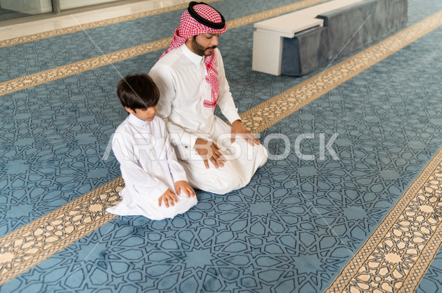 تعليم أداء فريضة الصلاه للطفل داخل المسجد، رجل سعودي يصلي في المصلى بجانب ابنه البالغ ،الخشوع في الصلاه ، أداء فريضة الصلاه في المسجد ، العبادة و التقرب الى الله ، تعليم الصلاة للأطفال