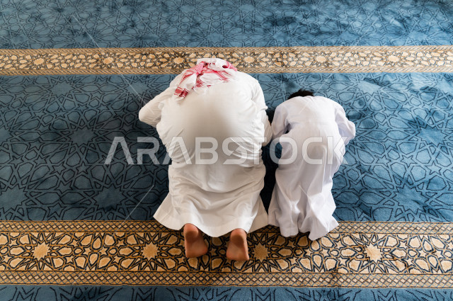 تعليم أداء فريضة الصلاه للطفل داخل المسجد، رجل سعودي يصلي في المصلى بجانب ابنه البالغ ،الخشوع في الصلاه ، أداء فريضة الصلاه في المسجد ، العبادة و التقرب الى الله ، تعليم الصلاة للأطفال