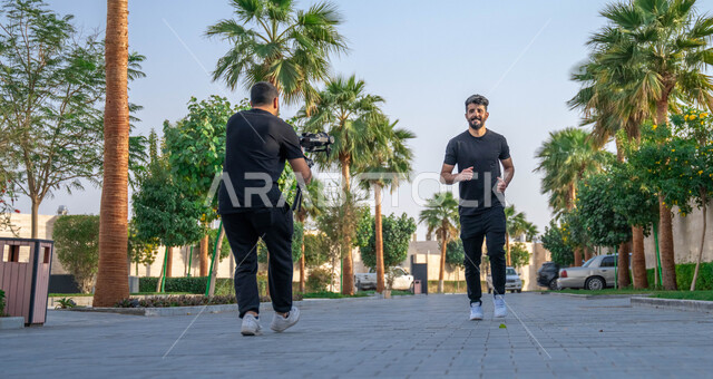 الحفاظ على الرشاقه والنشاط البدني، ممارسة التمارين الرياضيه، جلسة تصوير في احدى الحدائق للعامه، مصور عربي خليجي سعودي يقوم بتصوير شاب يمارس رياضة الجري في الهواء الطلق، خلفية الطبيعه