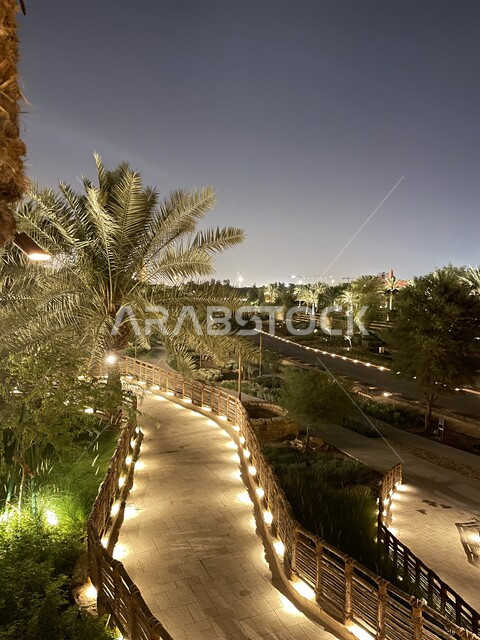 أشجار النخيل والنباتات الخضراء في مطل الدرعية المضاء في الليل، أماكن ومعالم سياحية شعبية تراثية لجذب السائحين إلى المملكة العربية السعودية، مناطق تاريخية قديمة في مدينة الرياض