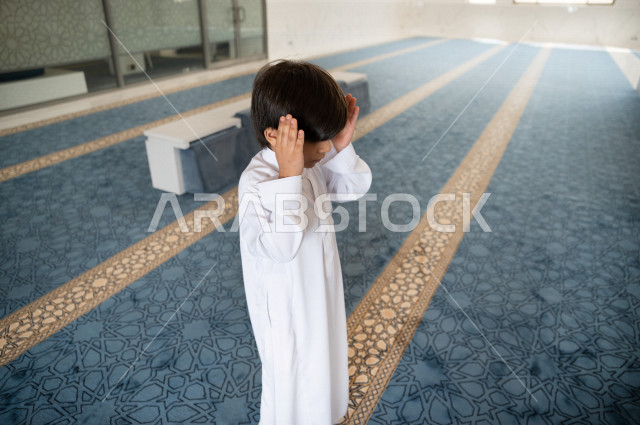 تعلم أداء فريضة الصلاه لطفل صغير داخل المسجد، طفل صغير بالغ يتعلم كيفية الصلاه  ، أداء فريضة الصلاه في المسجد ، العبادة و التقرب الى الله ، تعليم الصلاة للأطفال