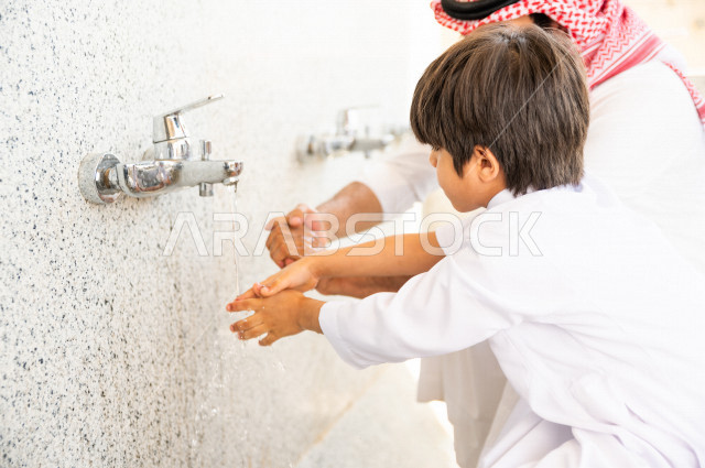 تعلم كيفية الوضوء و الطهارة  لطفل صغير مع والده  داخل المسجد، طفل صغير بالغ يتعلم كيفية الوضوء ، العبادة و التقرب الى الله ، تعليم الصلاة للأطفال