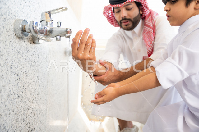تعلم كيفية الوضوء و الطهارة  لطفل صغير مع والده  داخل المسجد، طفل صغير بالغ يتعلم كيفية الوضوء ، العبادة و التقرب الى الله ، تعليم الصلاة للأطفال