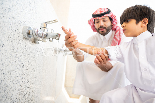 Learn how to perform ablution and purification for a small child with his father inside the mosque, a small adult child learns how to perform ablution, worship and draw closer to God, teach prayer to children