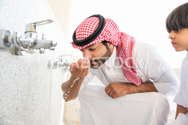 تعلم كيفية الوضوء و الطهارة  لطفل صغير مع والده  داخل المسجد، طفل صغير بالغ يتعلم كيفية الوضوء ، العبادة و التقرب الى الله ، تعليم الصلاة للأطفال