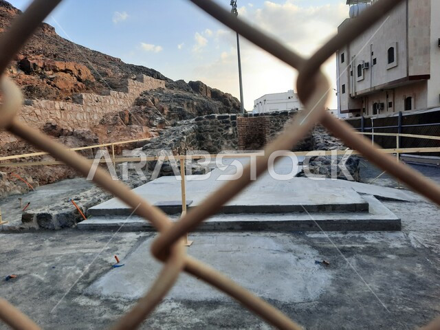 A picture from behind the metal grilles of the square surrounding Mount Uhud in Medina, ancient historical Islamic landmarks, tourism in famous religious places in Saudi Arabia