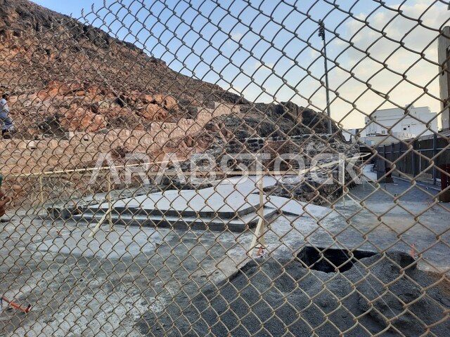 صورة من خلف الشباك المعدنيه للساحه المحيطه بجبل احد في المدينه المنوره ، معالم اسلاميه تاريخيه قديمه، السياحه في الاماكن الدينيه المشهورة في السعوديه