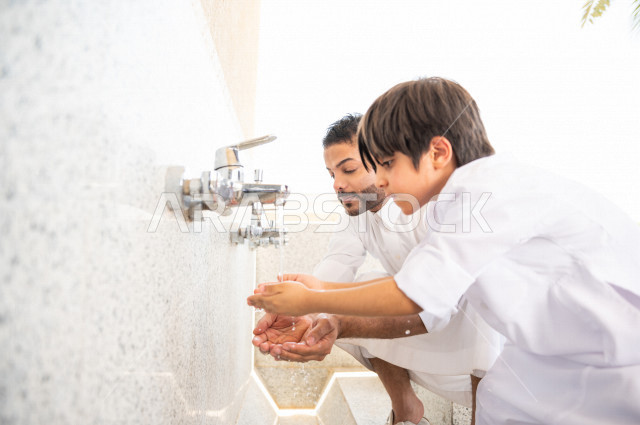 تعلم كيفية الوضوء و الطهارة  لطفل صغير مع والده  داخل المسجد، طفل صغير بالغ يتعلم كيفية الوضوء ، العبادة و التقرب الى الله ، تعليم الصلاة للأطفال