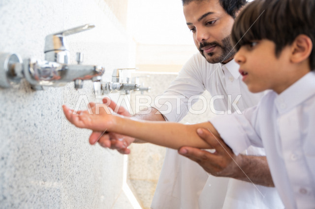تعلم كيفية الوضوء و الطهارة  لطفل صغير مع والده  داخل المسجد، طفل صغير بالغ يتعلم كيفية الوضوء ، العبادة و التقرب الى الله ، تعليم الصلاة للأطفال