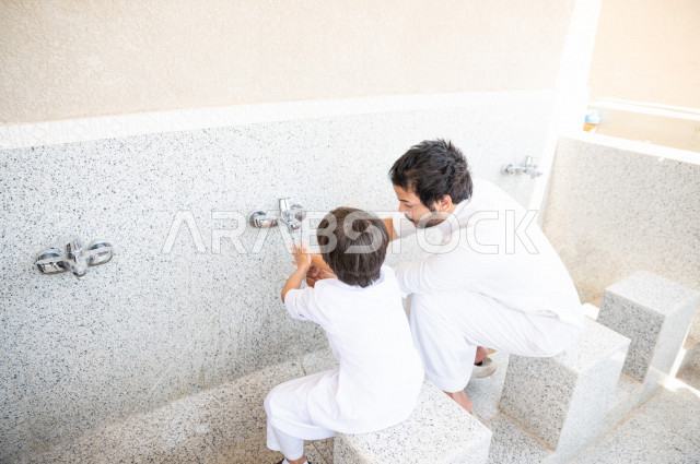 تعلم كيفية الوضوء و الطهارة  لطفل صغير مع والده  داخل المسجد، طفل صغير بالغ يتعلم كيفية الوضوء ، العبادة و التقرب الى الله ، تعليم الصلاة للأطفال