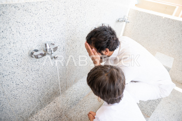 تعلم كيفية الوضوء و الطهارة  لطفل صغير مع والده  داخل المسجد، طفل صغير بالغ يتعلم كيفية الوضوء ، العبادة و التقرب الى الله ، تعليم الصلاة للأطفال