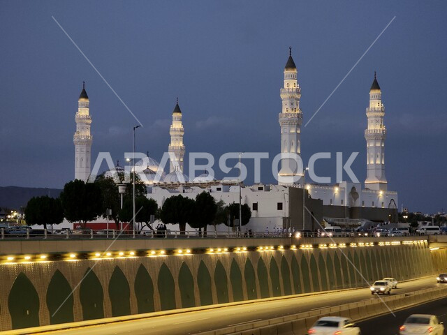 The architectural art of the Quba Mosque building in Medina at sunset, sacred religious landmarks and places in the Kingdom of Saudi Arabia, worship and closeness to God, minarets and illuminated domes, Islamic decorations in the modern style