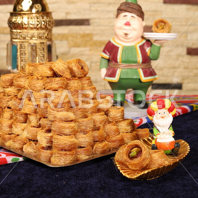 فانوس وتحف وزينة رمضان، قطع الحلوى الشهية، مأكولات غنية بالسكريات والسعرات الحرارية، حلى البقلاوة بالفستق والمكسرات، صورة مقربة لأطباق من الحلويات العربية الشرقية، ضيافة رمضانية لذيذة