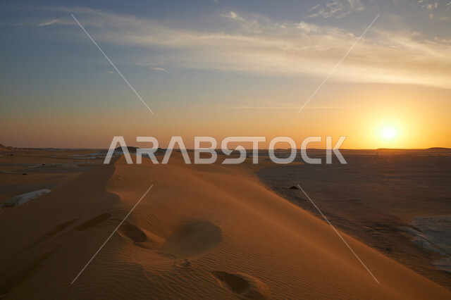 الرمال الذهبية الناعمة، منظر السماء المليئة بالغيوم البيضاء في وقت الغروب، المناظر الطبيعية في الاماكن سياحية مشهورة، معالم اثرية تاريخية قديمة، جذب واستقطاب السائحين، الكثبان الرملية في صحراء السعودية
