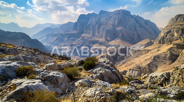  منظر الغيوم والسحب البيضاء في السماء فوق التضاريس الطبيعية والتكوينات والتشكلات الصخرية، صورة جوية لسلسلة جبال القارة في النهار، القمم والمرتفعات الجبلية في مدينة الاحساء، المعالم التاريخية الأثرية القديمة في المملكة العربية السعودية