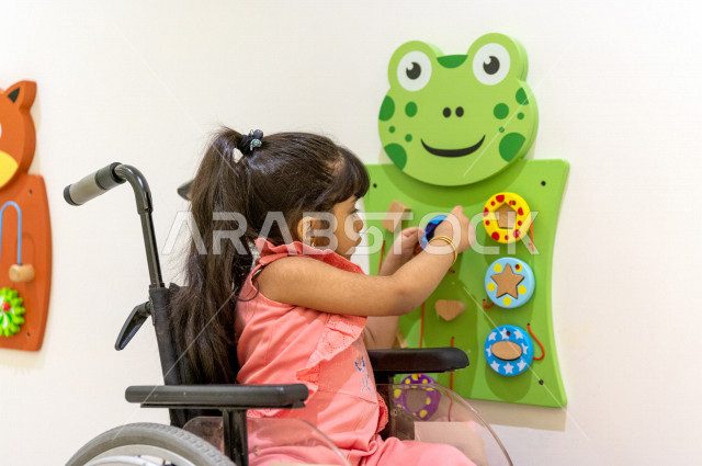 A Saudi girl crippled in a kindergarten, she performs many fun and different activities, a girl with special needs, a group of individual activities that the child of determination does, integrating people with special needs in kindergartens and incubator