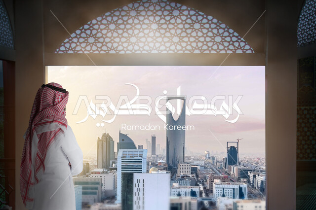 التطور والتقدم العمراني في المملكة العربية السعودية, صورة من الخلف لرجل عربي خليجي سعودي يرتدي الثوب التقليدي والشماغ ينظر إلى شيء ما, مخطوطة رمضان كريم باللغة العربية, الاستعداد لاستقبال شهر الخير, خلفية الأبراج وناطحات السحاب