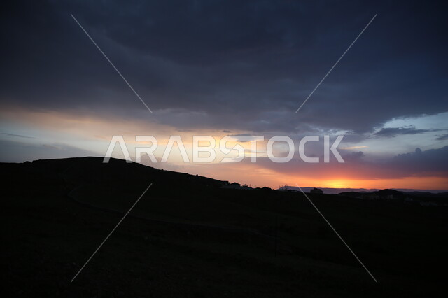 The sky full of white clouds at sunset, the view of trees, plants and herbs in the city of Abha, cities and tourist places in the Kingdom of Saudi Arabia, lands and vast green spaces, nature background