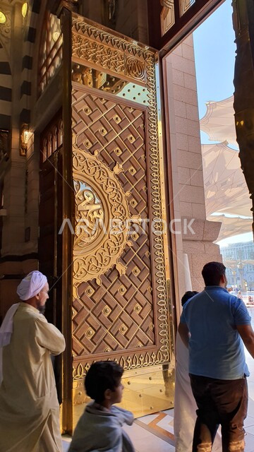 Entrance gate to the Prophet’s Mosque, performing prayers in the Prophet’s Mosque in Medina, worship and getting closer to God, sacred religious landmarks and places in Saudi Arabia, interior decorations and designs in the Islamic style